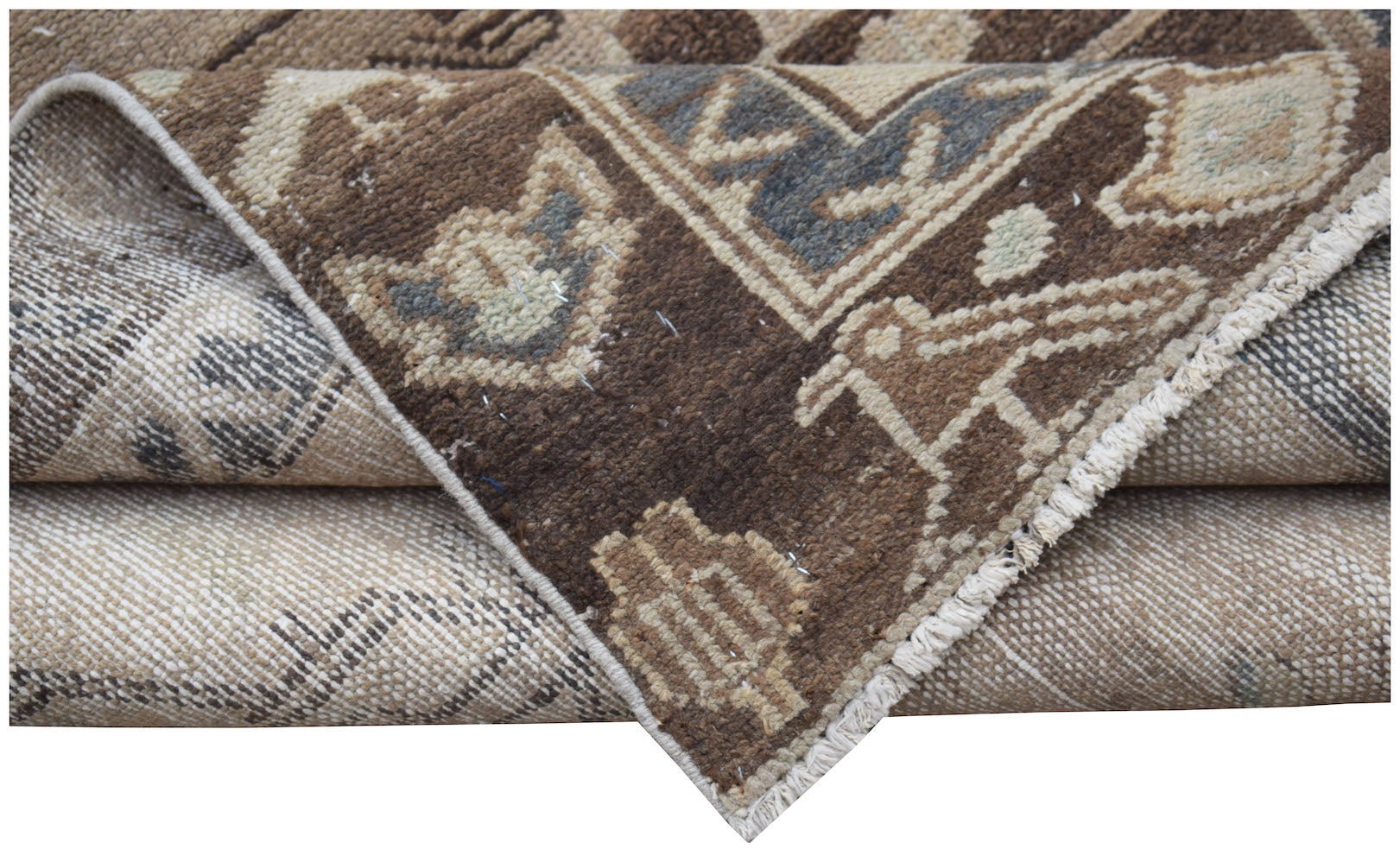 A folded vintage Persian Hamadan runner featuring a brown and beige geometric wool pattern.