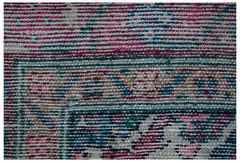 A close-up of a vintage Persian Hamadan runner featuring intricate patterns in pink, blue, and tan.