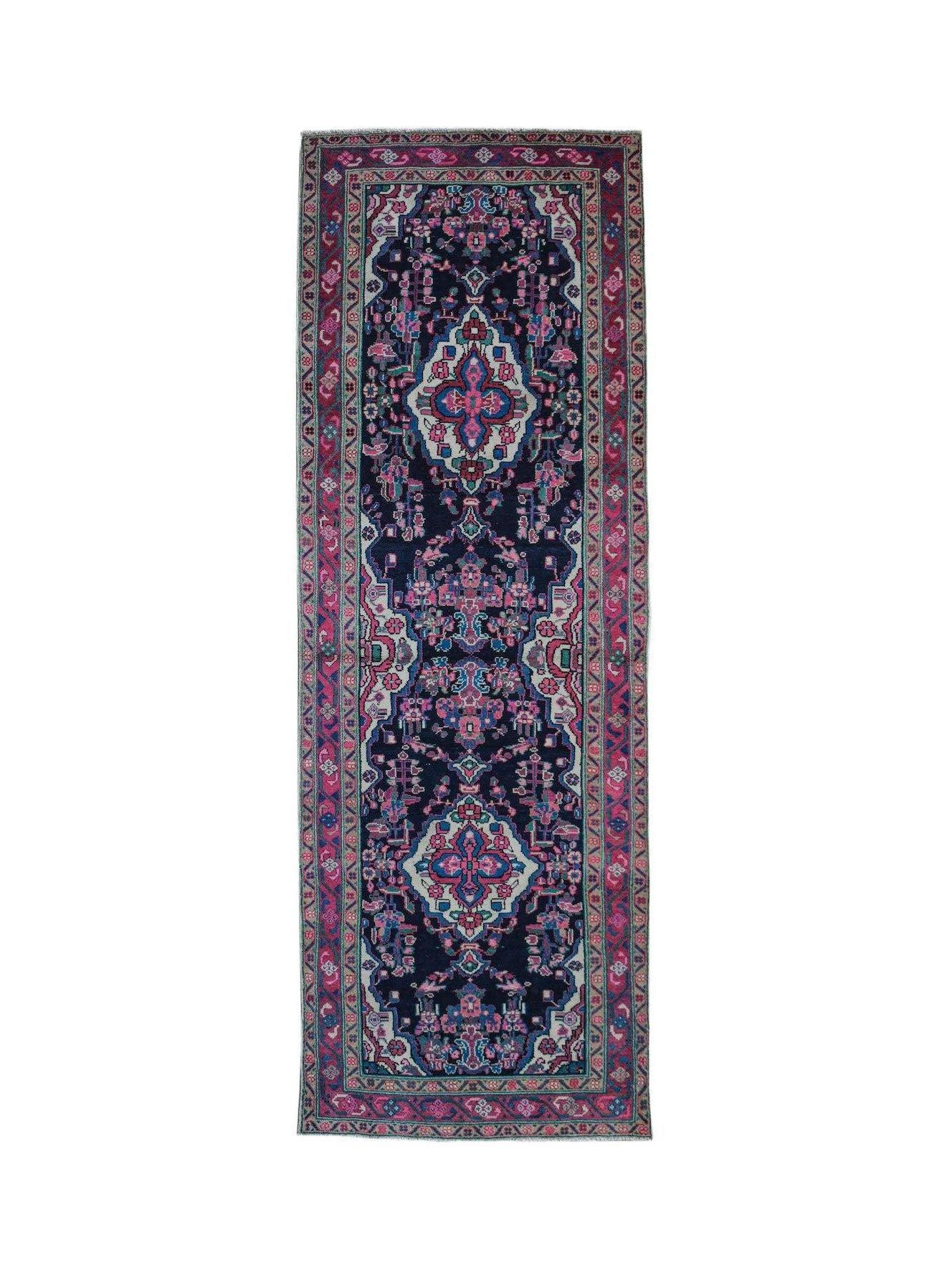 A vintage handwoven Persian Hamadan runner featuring a dark blue field with pink floral motifs.