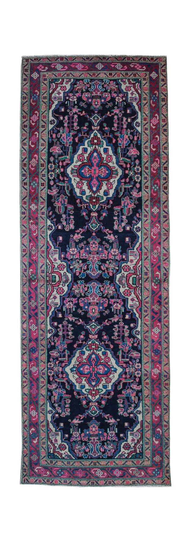 A vintage handwoven Persian Hamadan runner featuring a dark blue field with pink floral motifs.
