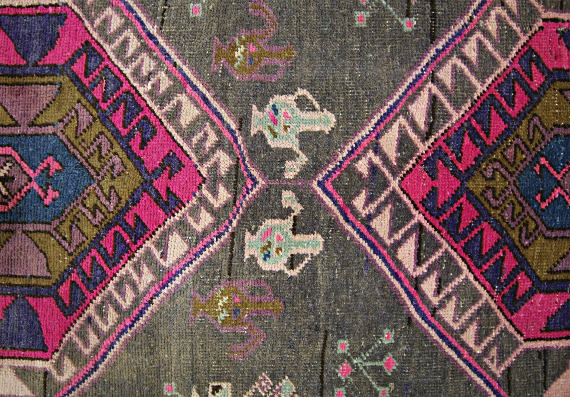 A vintage Persian Hamadan runner featuring geometric diamond patterns in vibrant pink and blue.