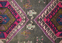 A vintage Persian Hamadan runner featuring geometric diamond patterns in vibrant pink and blue.