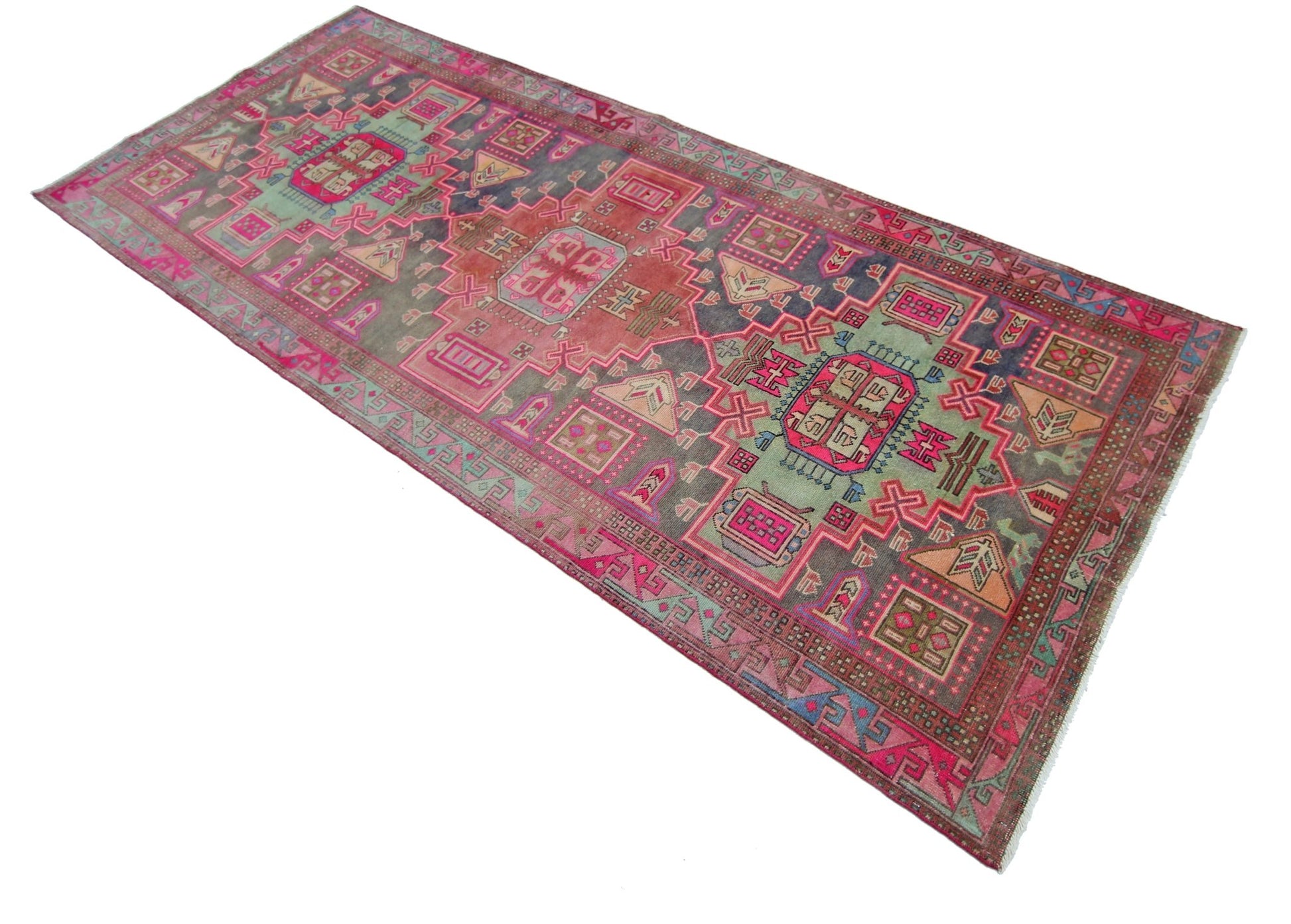 A vintage Persian Hamadan runner featuring geometric patterns in shades of pink, green, and grey.