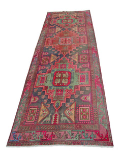 A vintage Persian Hamadan runner featuring geometric patterns in vibrant pink, green, and blue.