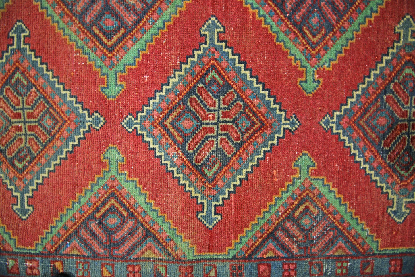 A vintage Persian Hamadan runner featuring a repeating geometric diamond pattern in red and blue.