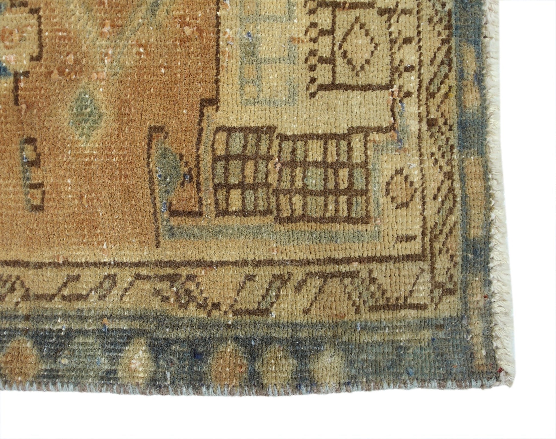 A close-up of a vintage Persian Hamadan runner featuring geometric patterns in muted earth tones.