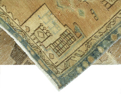 A corner view of a vintage Persian Hamadan runner featuring geometric patterns in tan and blue.