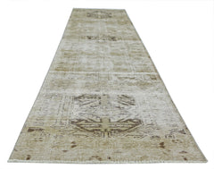 A vintage Persian Hamadan runner rug featuring a faded geometric pattern in neutral beige tones.