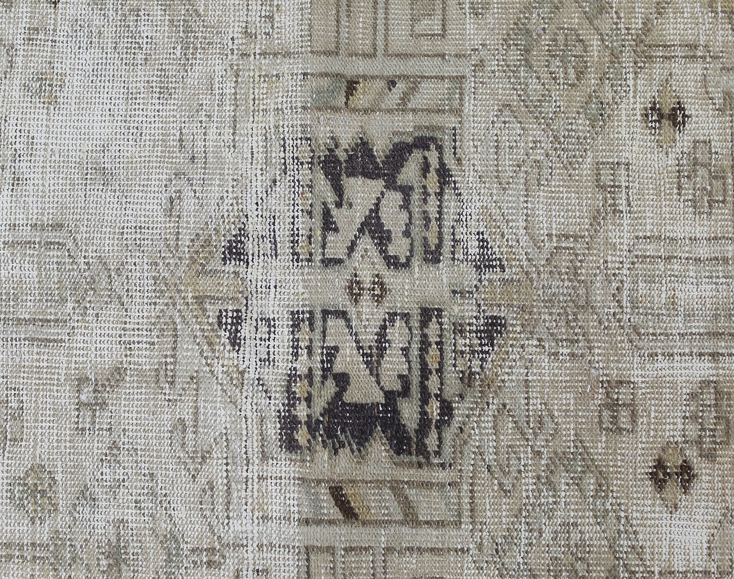 A close-up of a vintage Persian Hamadan runner featuring a faded geometric medallion pattern.