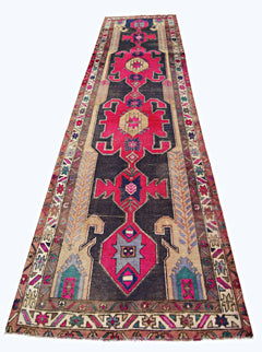 A vintage Persian Hamadan runner featuring geometric medallions in vibrant pink and dark blue.