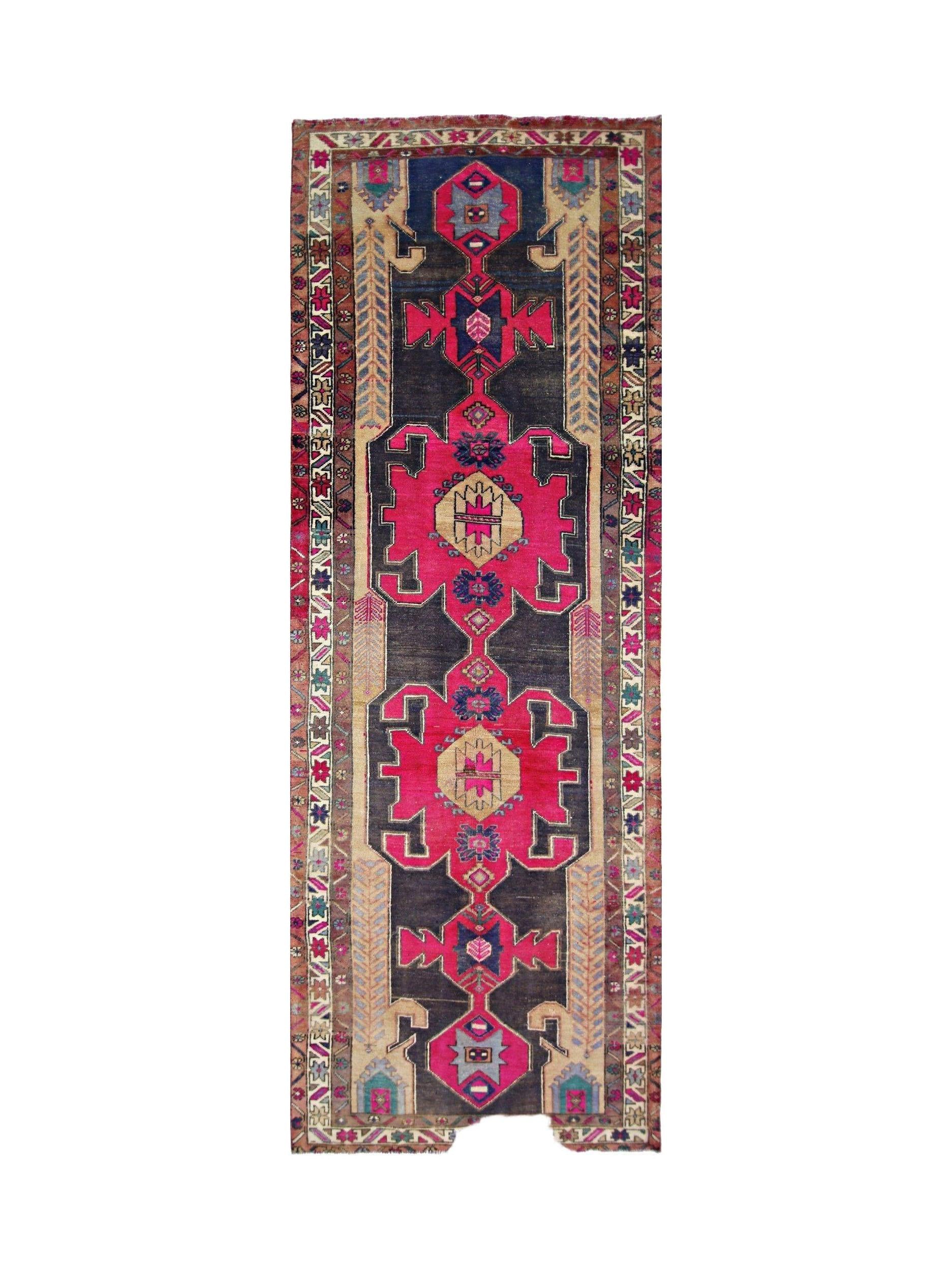 A vintage Persian Hamadan runner featuring geometric medallions in vibrant pink and dark blue.