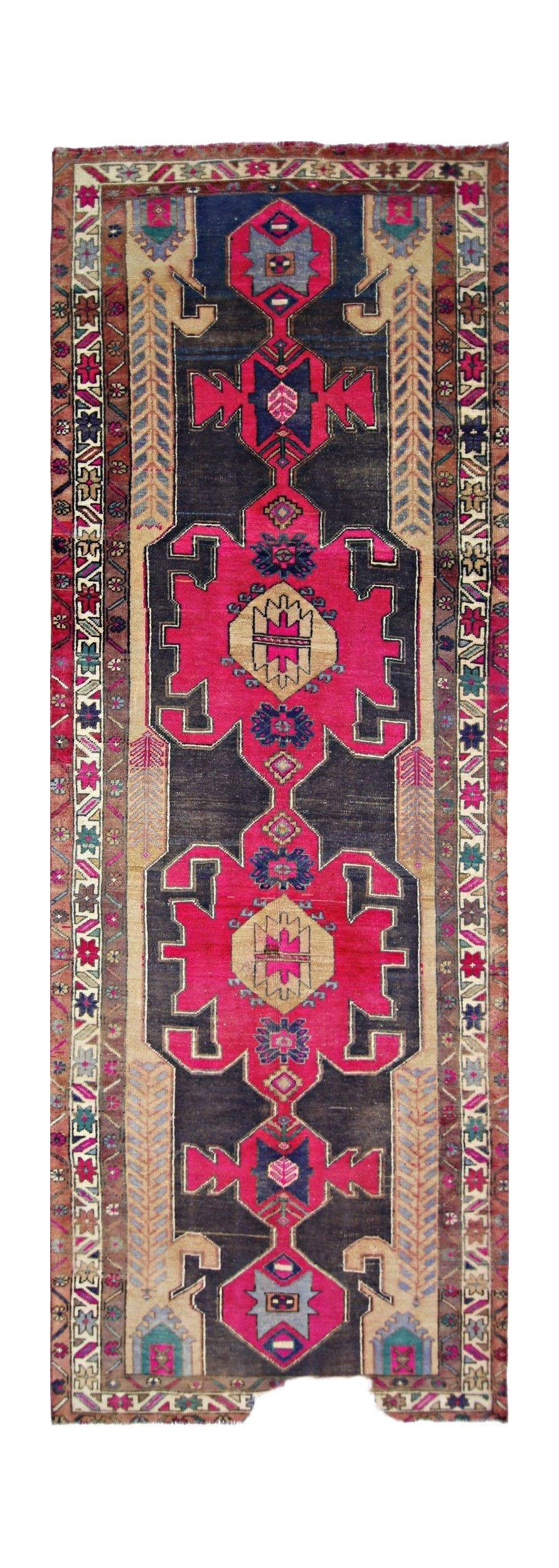 A vintage Persian Hamadan runner featuring geometric medallions in vibrant pink and dark blue.