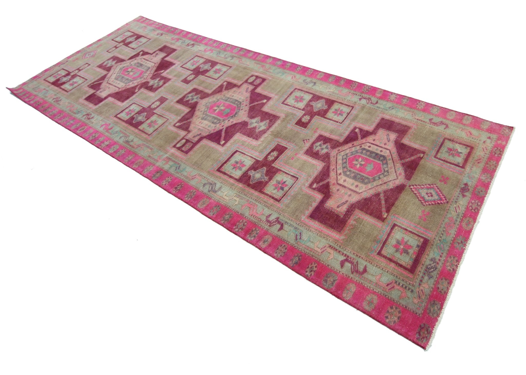 A vintage Persian Hamadan runner featuring geometric medallions in shades of pink and beige.
