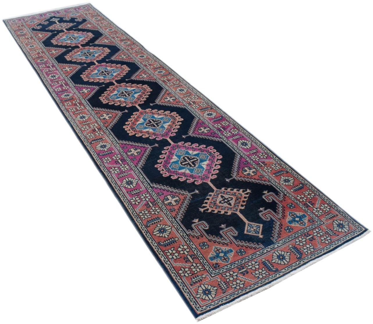 A vintage Persian Hamadan runner featuring a dark blue field with repeating geometric medallions.