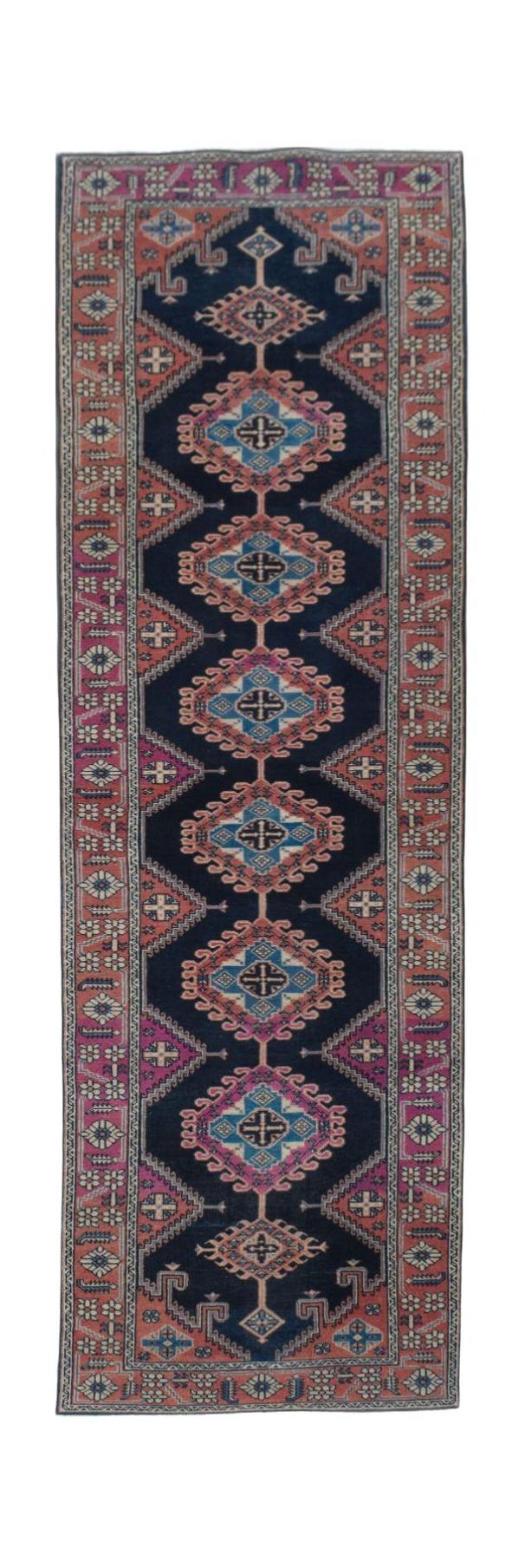 A vintage Persian Hamadan runner featuring a dark blue field with repeating geometric medallions.