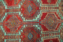 A vintage Persian Hamadan runner featuring geometric diamond patterns in red and teal wool.