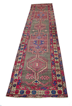 A vintage Persian Hamadan runner featuring geometric patterns in shades of pink, blue, and grey.