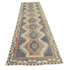 A vintage Persian Hamadan runner rug featuring a geometric diamond pattern in blue and coral tones.