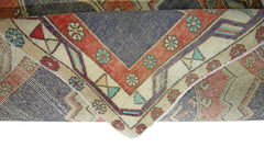 A corner view of a vintage Persian Hamadan runner featuring geometric floral patterns in red, blue, and cream.