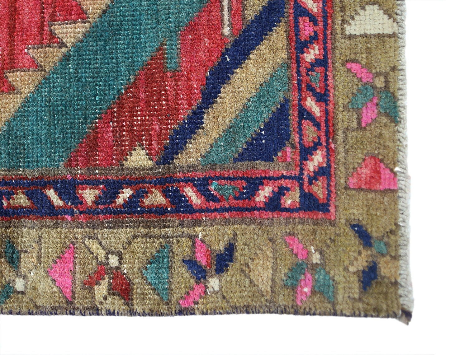 A close-up of a vintage Persian Hamadan runner featuring geometric patterns in red, blue, and green.