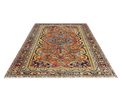 A vintage Persian Heriz rug featuring a central blue medallion on a rust-colored field.