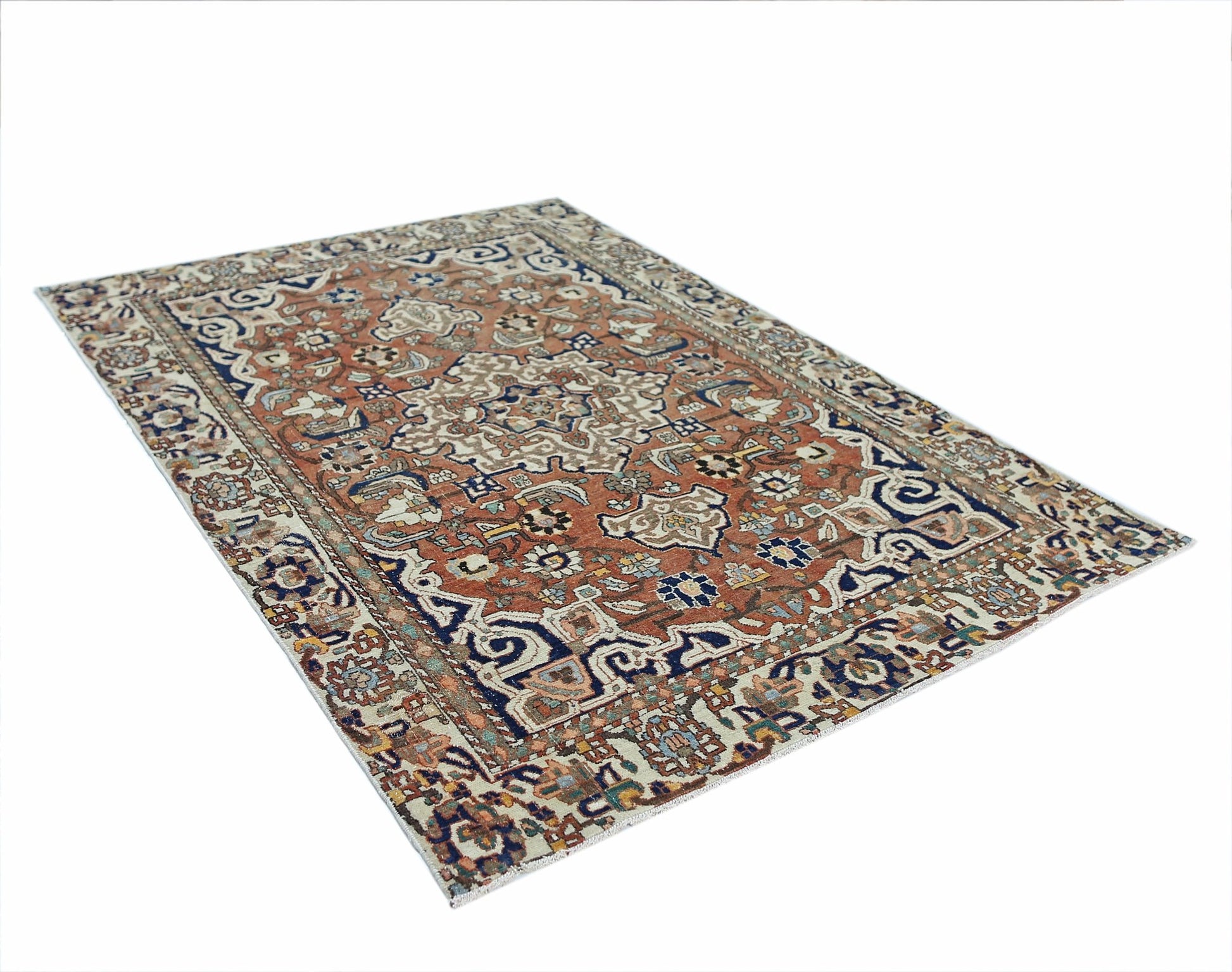 A vintage Persian Heriz rug featuring a geometric medallion pattern in rust, blue, and cream tones.