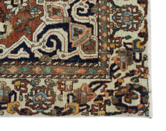 A vintage Persian Heriz rug featuring a geometric pattern in red, blue, and cream tones.