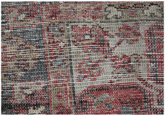 A close-up view of a vintage Persian Heriz rug featuring intricate geometric patterns in wool.