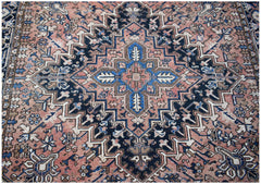 A vintage handwoven Persian Heriz rug featuring a geometric medallion in blue, pink, and cream.