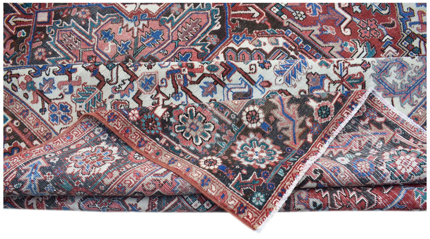 A vintage handwoven Persian Heriz rug featuring intricate floral patterns in red, blue, and cream.