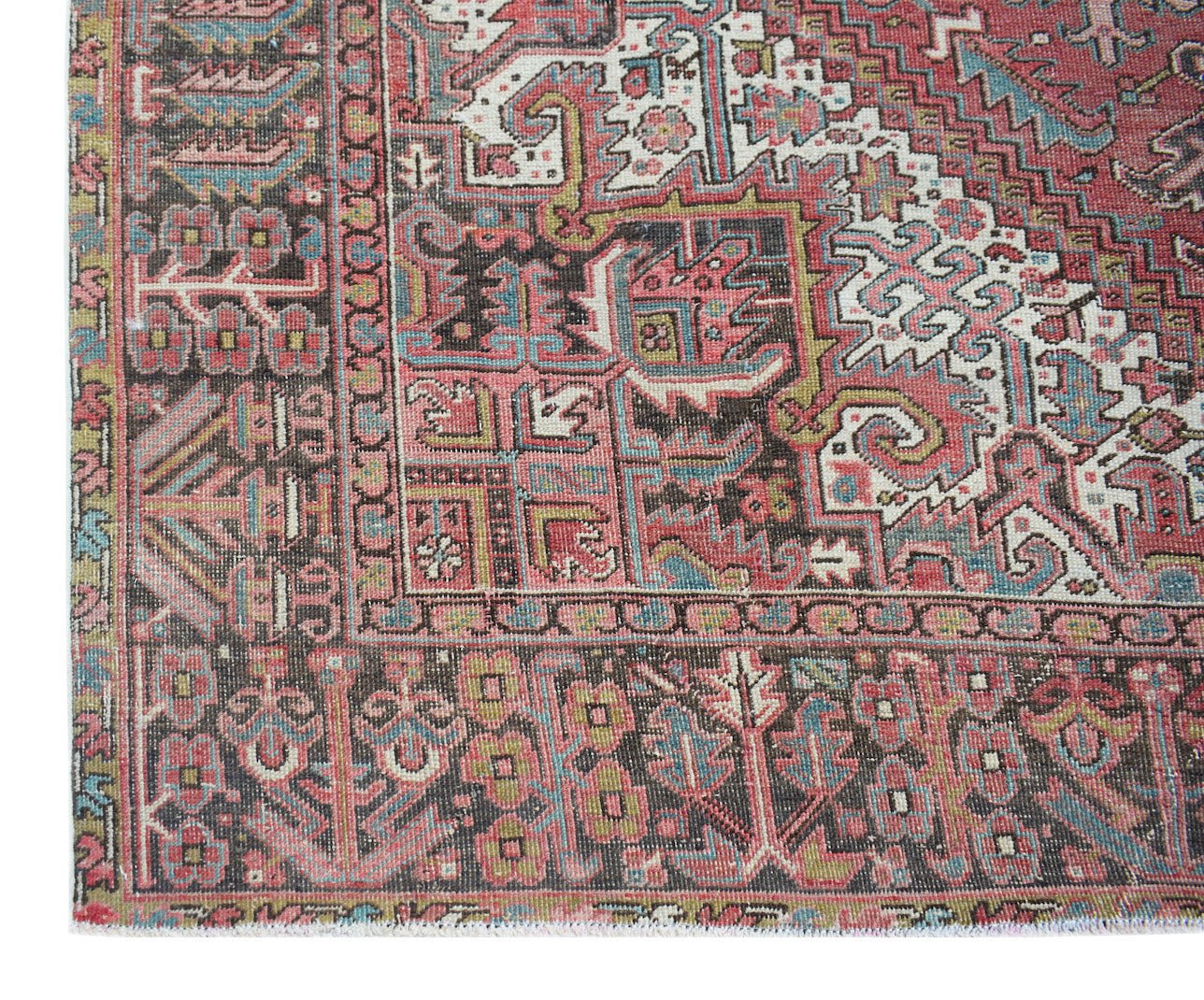 A vintage Persian Heriz rug featuring intricate geometric patterns in red, blue, and cream tones.