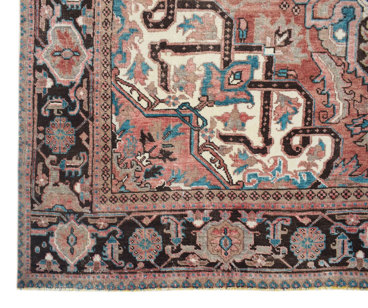 A vintage Persian Heriz rug featuring a geometric floral pattern in red, blue, and cream tones.