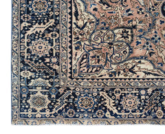 A vintage Persian Heriz rug featuring a geometric floral pattern in shades of blue and peach.