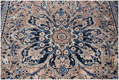 A vintage handwoven Persian Heriz rug featuring a large central floral medallion in blue and pink.