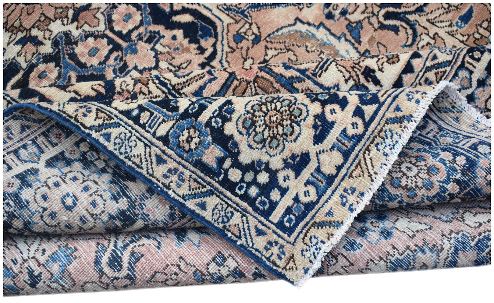 A vintage handwoven Persian Heriz rug featuring a traditional floral pattern in blue and pink tones.