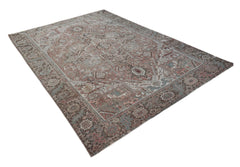 A vintage handwoven Persian Heriz rug featuring a traditional geometric pattern in muted tones.