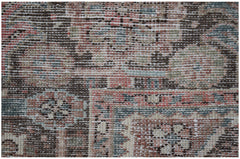 A close-up of a vintage Persian Heriz rug featuring a geometric pattern in muted earth tones.