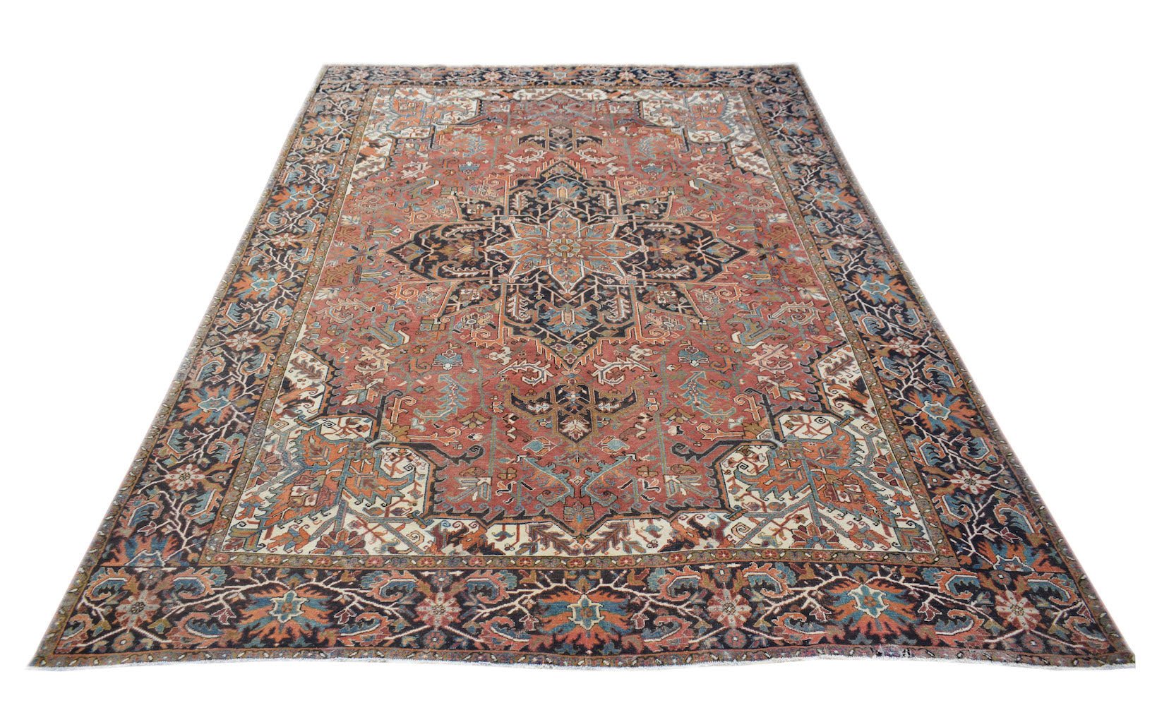 A vintage handwoven Persian Heriz rug featuring a central medallion on a rust-red field.