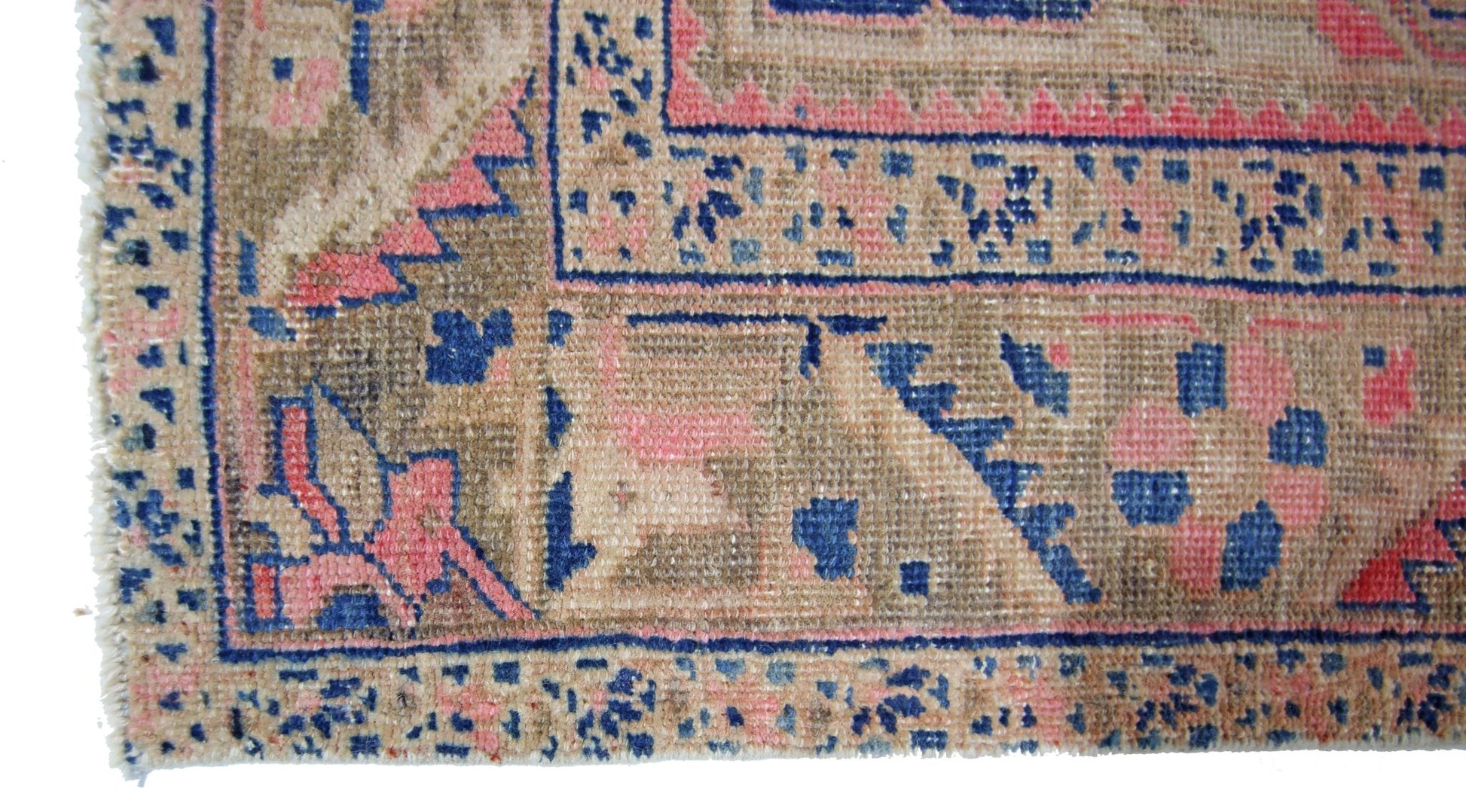 A vintage Persian Heriz runner featuring a geometric pattern in faded blue, pink, and tan tones.