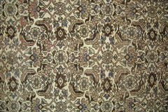 A vintage Persian rug featuring an intricate, repeating floral pattern in muted earth tones.