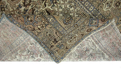 A vintage handmade Persian rug with intricate geometric patterns in muted blue and brown tones.