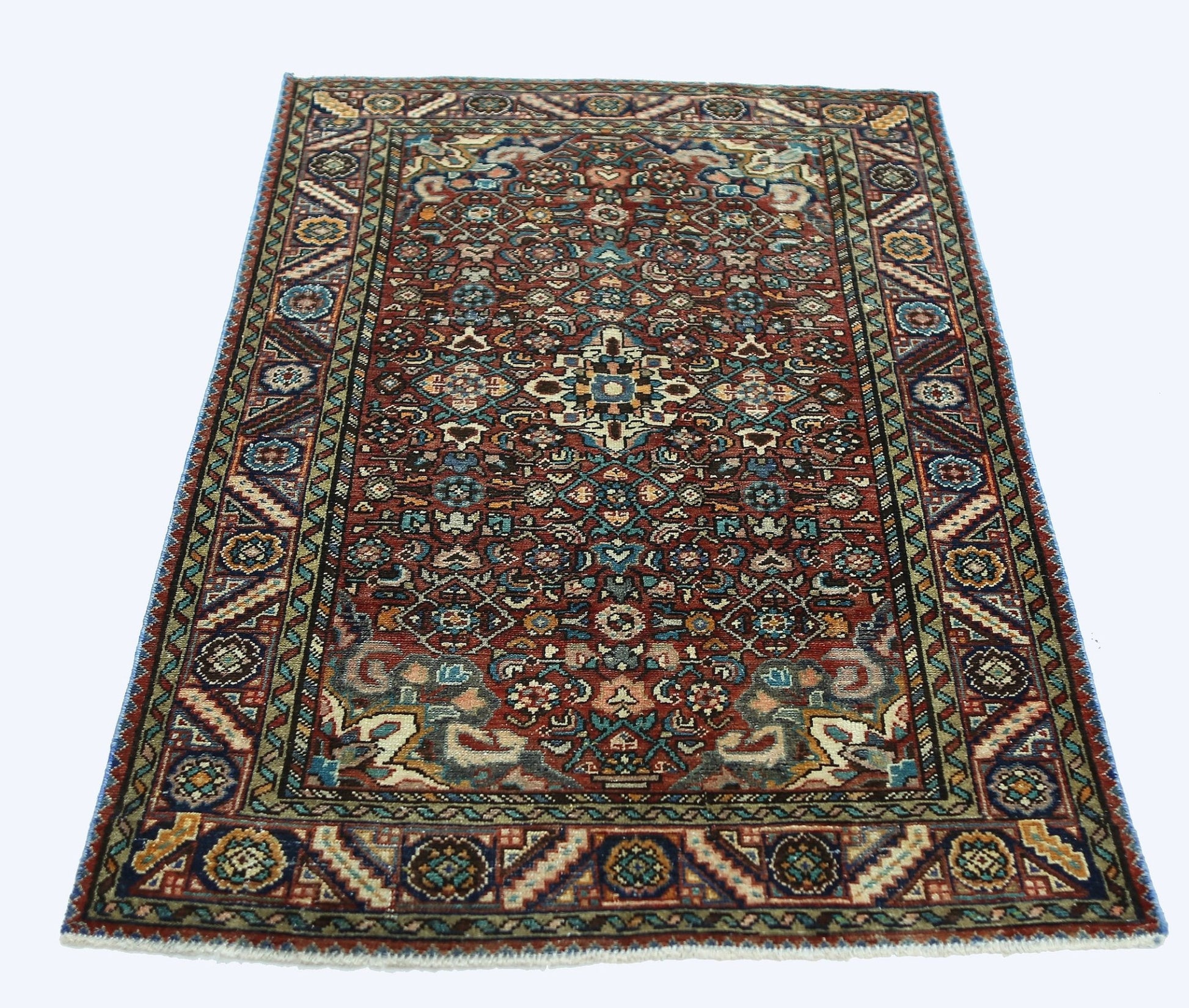 A rectangular vintage Persian rug featuring a detailed floral pattern in red, blue, and cream tones.
