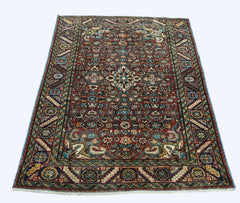 A rectangular vintage Persian rug featuring a detailed floral pattern in red, blue, and cream tones.