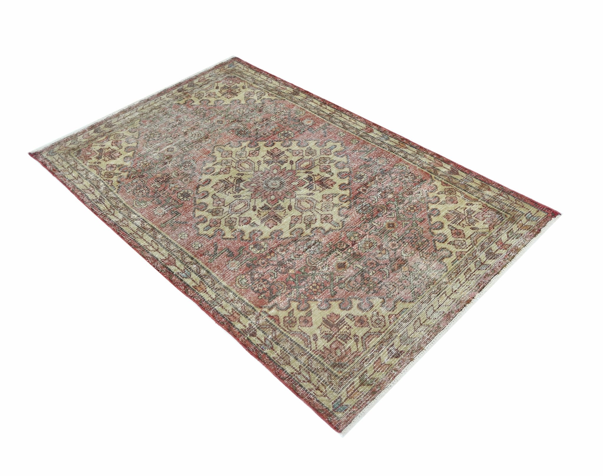 A vintage Persian rug featuring a traditional medallion pattern in faded red and beige tones.
