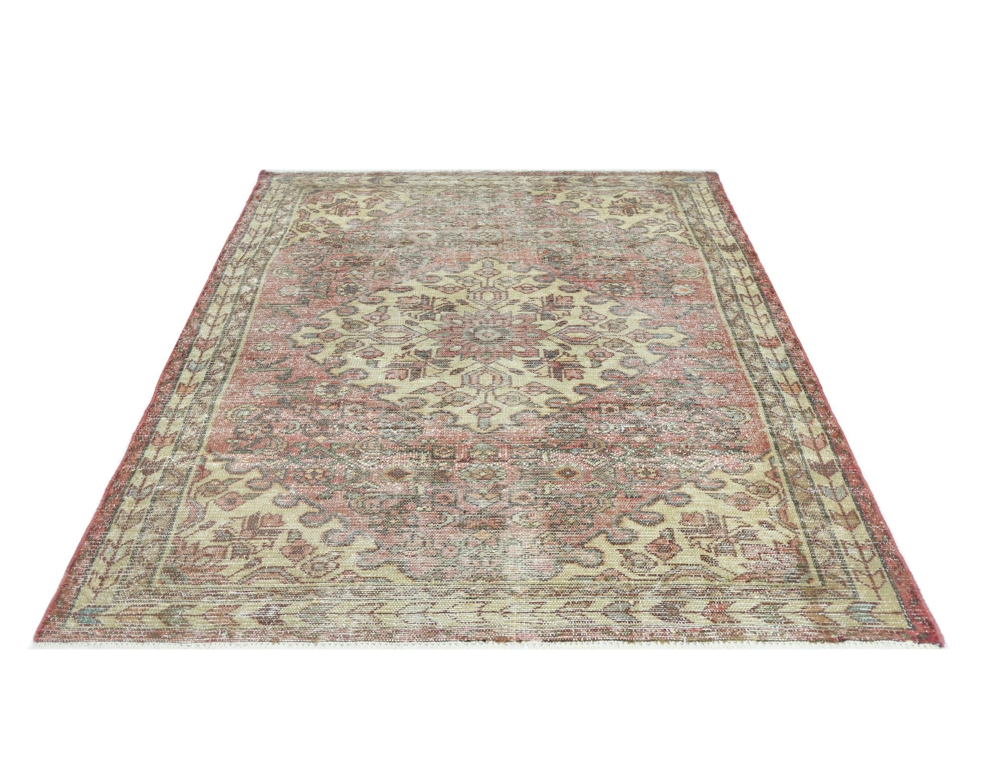 A vintage handmade Persian rug featuring a traditional floral medallion pattern in faded red tones.