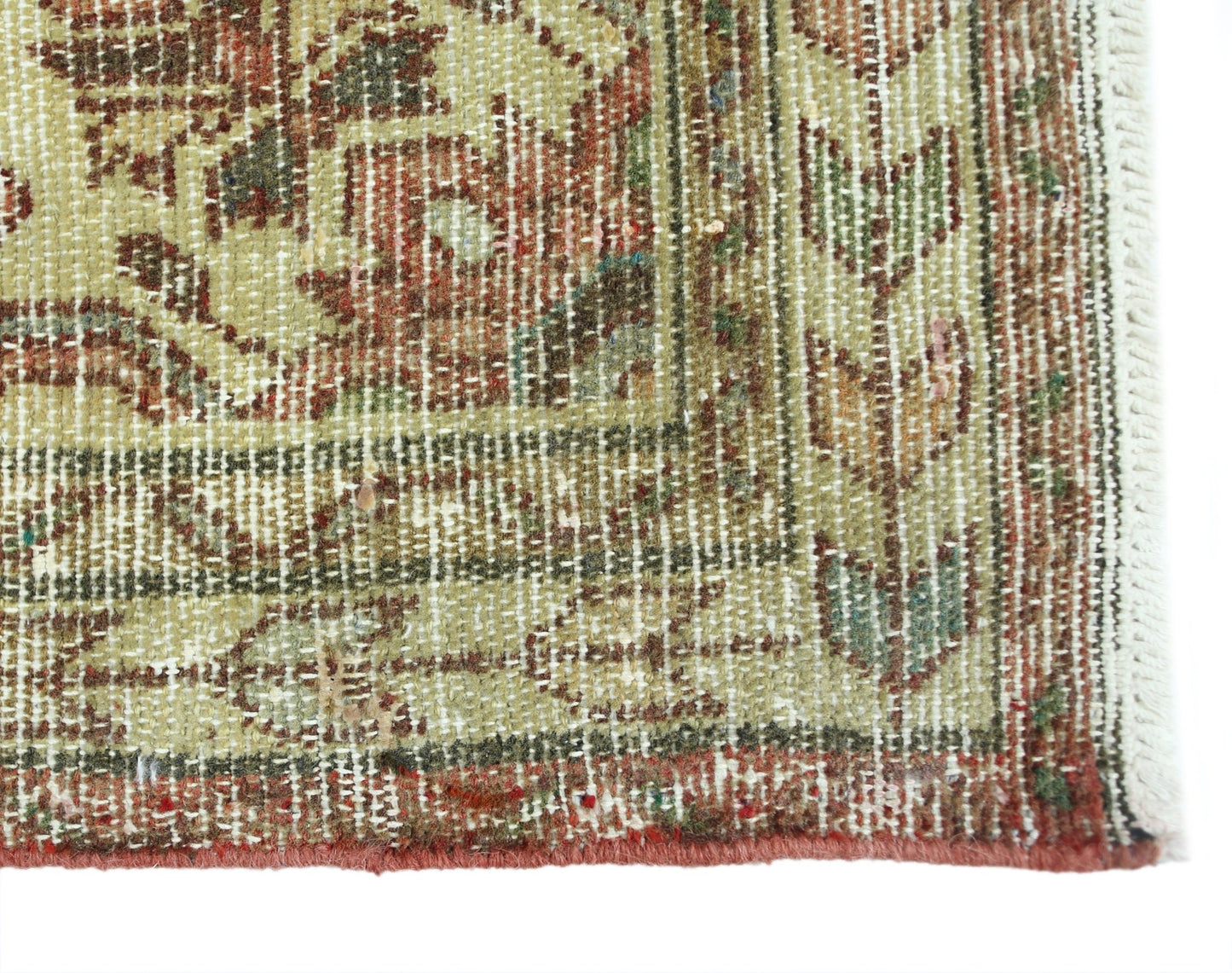 A close-up of a vintage Persian rug featuring intricate floral patterns in muted earth tones.