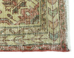 A close-up of a vintage Persian rug featuring intricate floral patterns in muted earth tones.
