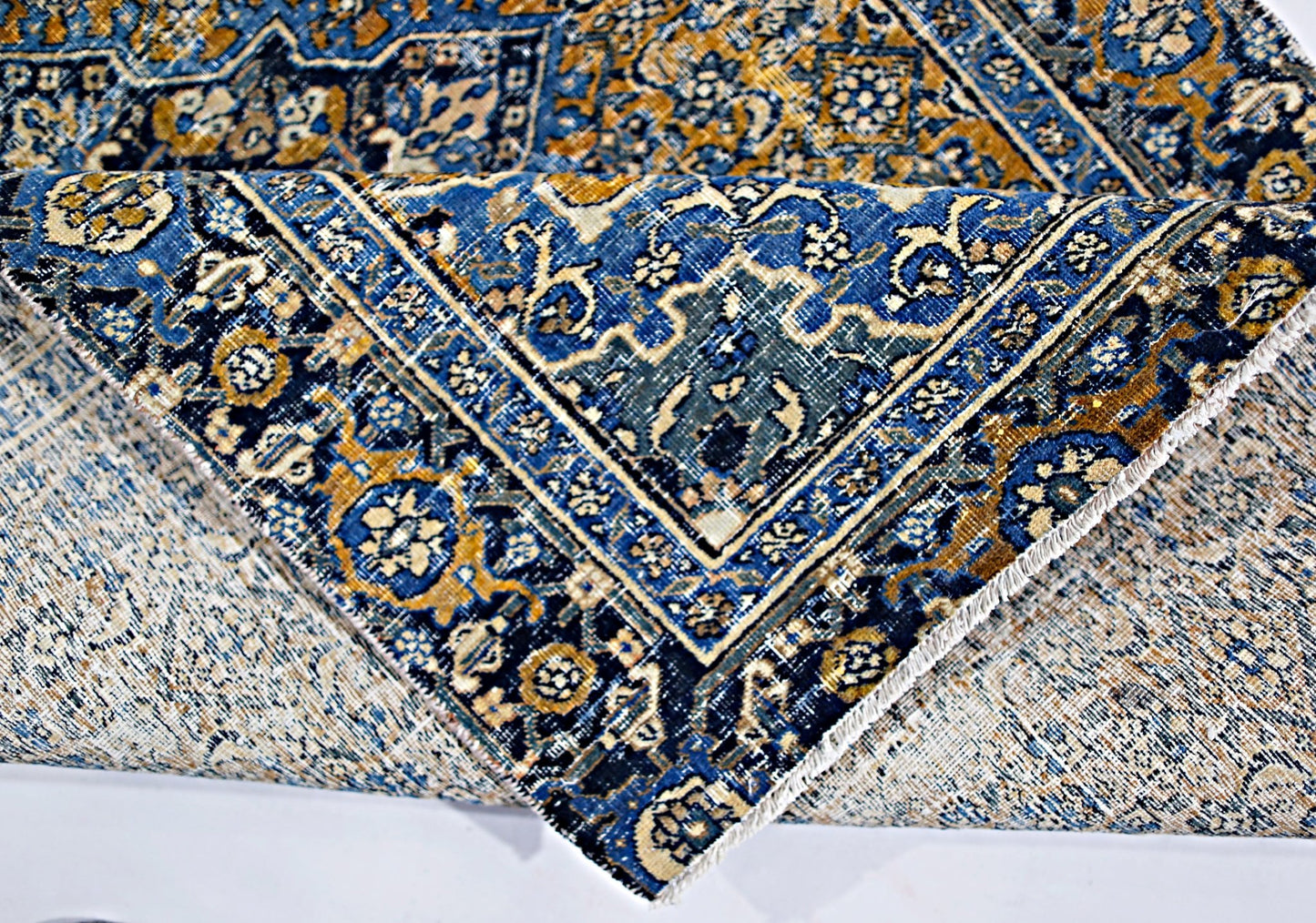 A vintage Persian Hossainabad rug featuring intricate blue and gold floral patterns.