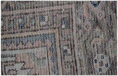 A close-up of a vintage Persian rug featuring intricate geometric patterns in muted earth tones.