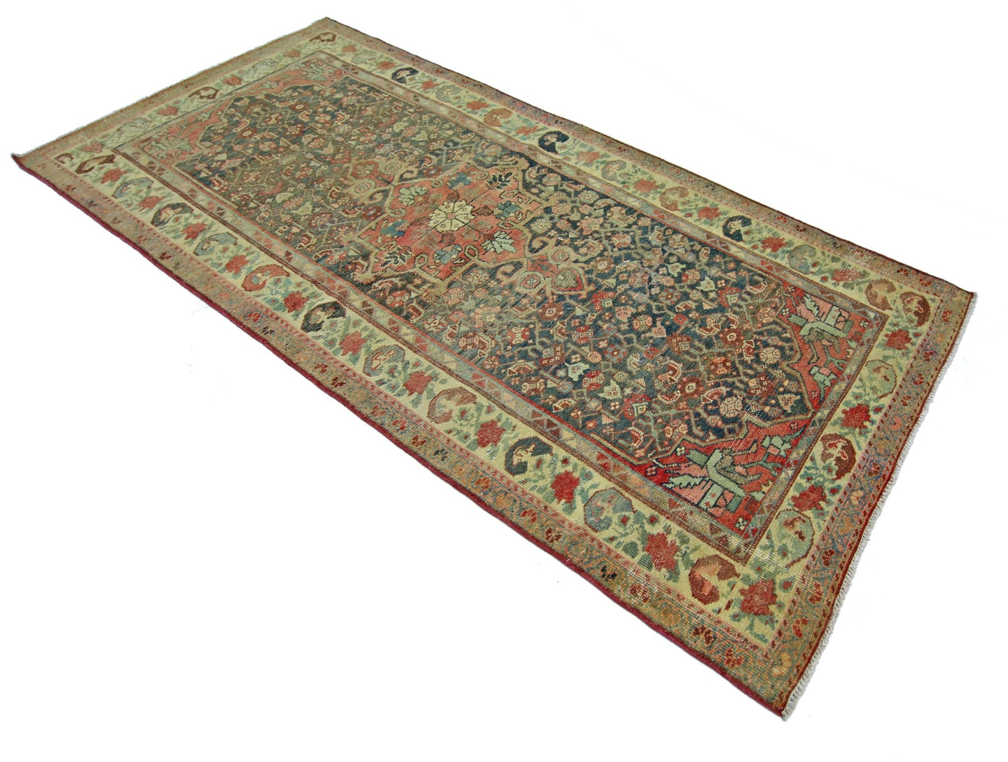 A rectangular vintage Persian rug featuring intricate floral patterns in muted red and blue tones.